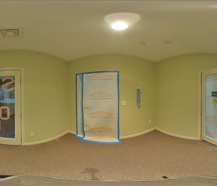 360-degree panoramic shot of a water-saturated carpet and walls in a commercial space with SERVPRO containment sheeting and t