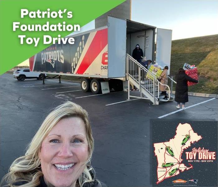 female standing in front of a large truck being loaded with toy dontations