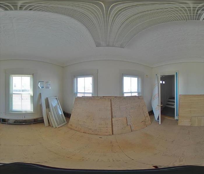 Panorama shot with fisheye lens view of a room with removed baseboards, lower drywall, and flooring