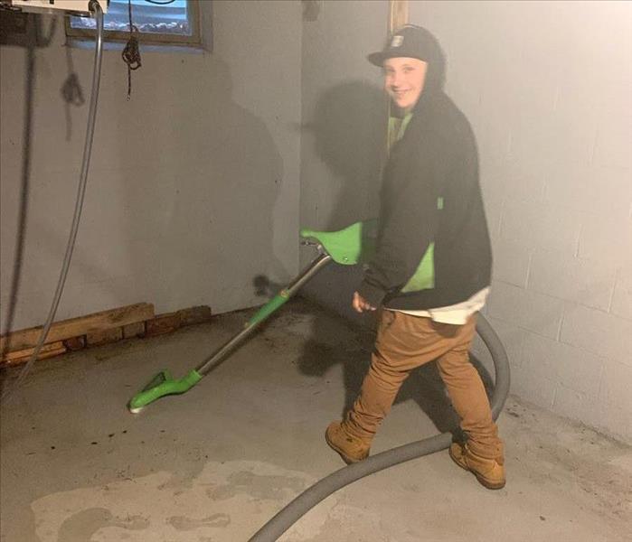 SERVPRO technician in basement with extraction equipment